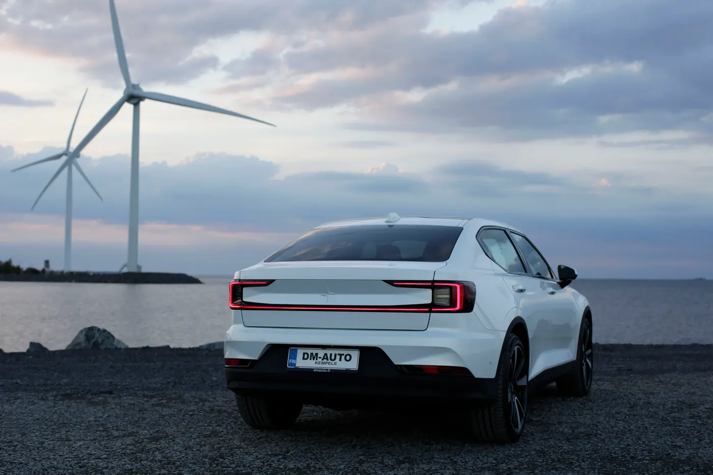 Valkoinen Polestar 2 takaa meren rannalla